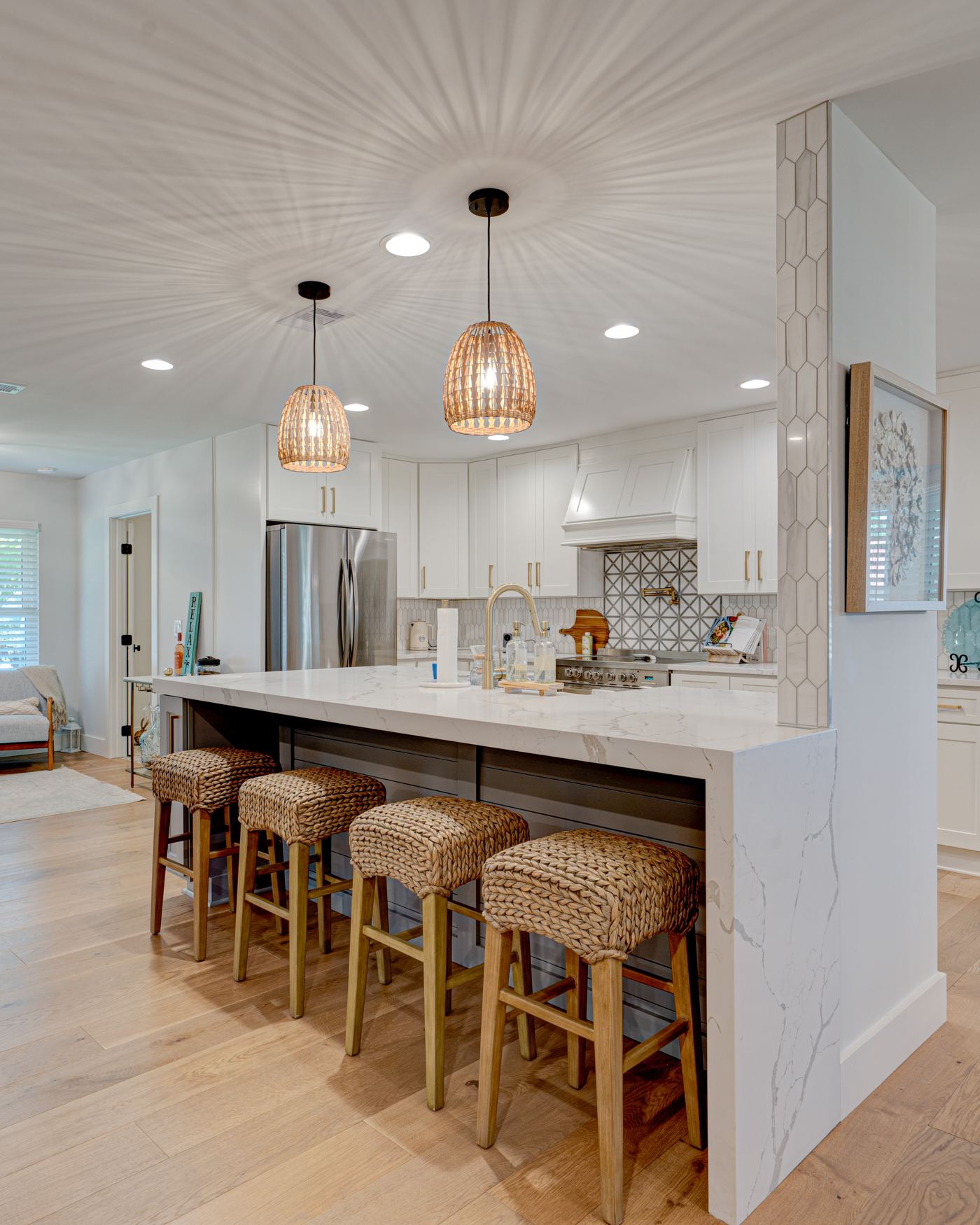 Warm open concept kitchen with marble waterfall island and natural wood floors — Coronado Photo & Media