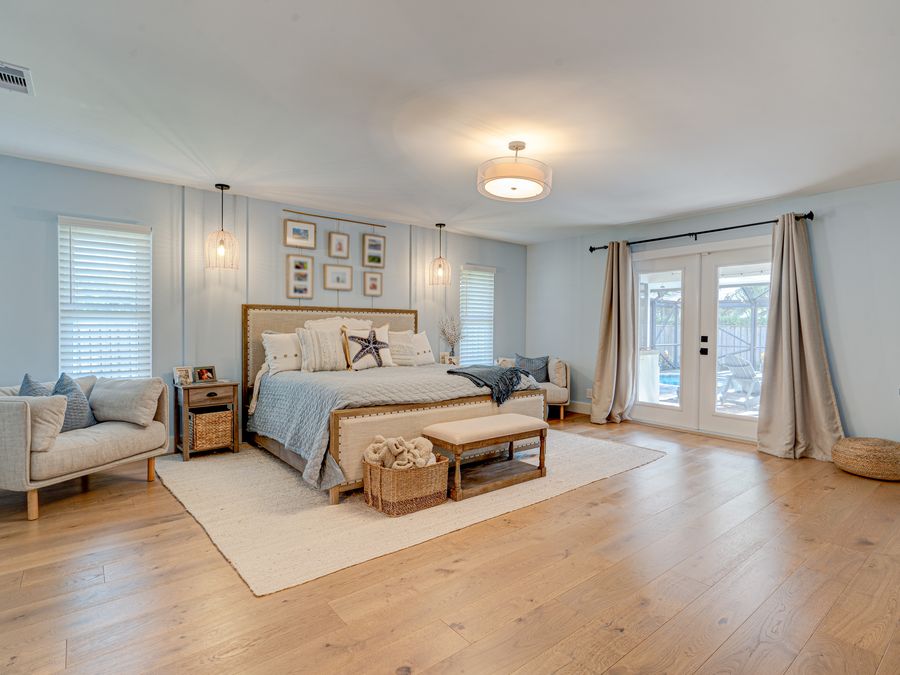 Coral Gables primary bedroom suite with pool view through french doors